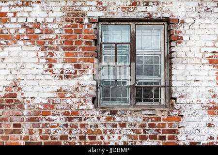 aged wooden window on weathered red brick wall painted white Stock Photo