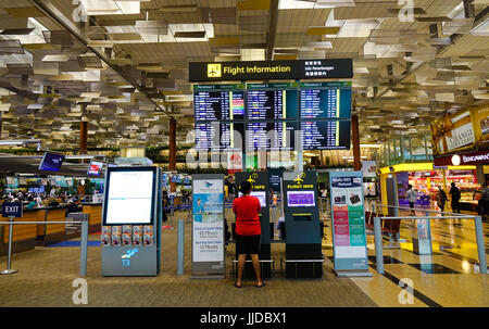 Singapore - Jun 14, 2017. People looking at information in Changi Airport, Singapore. Changi serves more than 100 airlines flying to some 380 cities i Stock Photo