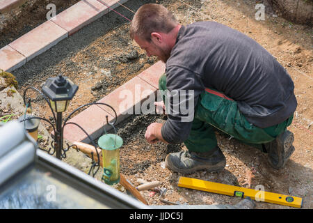 Close up, construction worker in making a bricklayer from bricks on construction site. Stock Photo