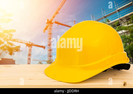 Yellow safety helmet and gloves on working surface at construction site Stock Photo