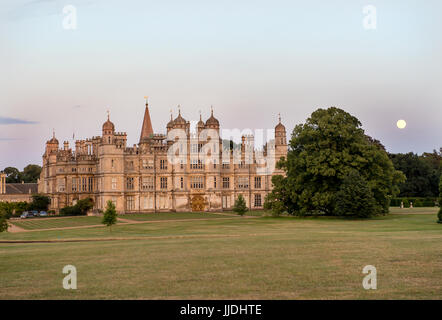 Burghley House in the early evening with the Moon rising Stock Photo