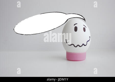 White cloud of thought is empty. Place under the text. Egg cheerful with a face alone on a white background concept of fear. Photo for your design Stock Photo