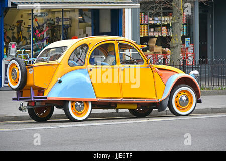 Citroen 2cv French car well maintained in unusual colours with rear mounted extended boot box & tow bar seen on UK road with obscured UK numberplate Stock Photo