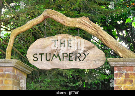 Stumpery entrance sign to shady woodland path devoted to artistically showing bits of dead rotting trees timber & growing lichens ferns & similar UK Stock Photo