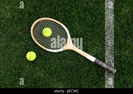 retro tennis racket on natural grass with balls. top view Stock Photo