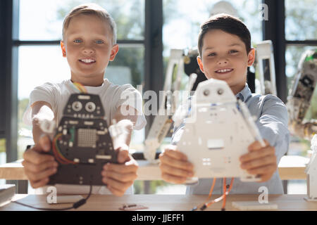 Upbeat boys demonstrating their robotic creations Stock Photo