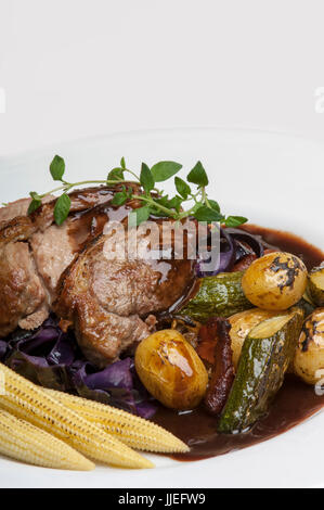 A Plate of Succulent Roast Lamb with Sauteed chanterelle mushrooms with a rosemary gravy Stock Photo