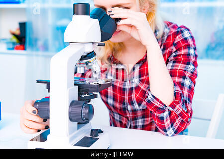 female student in biological classroom with science microscope Stock Photo