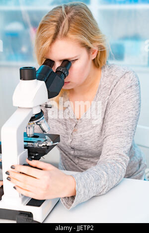 Student girl in microbiology class, learning workshop with microscope Stock Photo