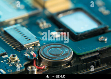 Disassembled mobile phone in the service center with internal components of the camera and speaker Stock Photo