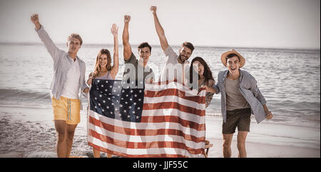 happy group of friends at the each holding an american flag Stock Photo