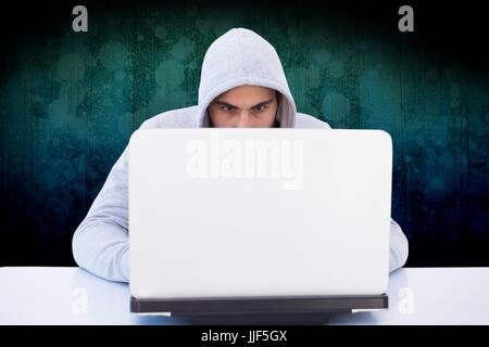 Digital composite of hacker using his laptop against dark background Stock Photo