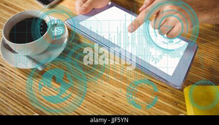 Digital composite of Hands holding digital tablet with various symbols and cup of tea on wooden table Stock Photo