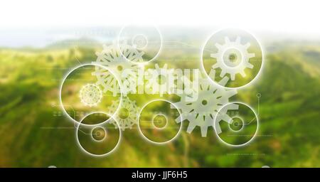 Digital composite of White gear graphics against green blurry mountains Stock Photo