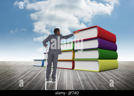 Digital composite of Business man on a ladder against books Stock Photo