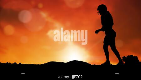 Digital composite of Silhouette rugby player on field against sky during sunset Stock Photo