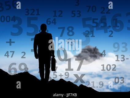 Digital composite of businessman silhouette on the top of the mountain, looking to other mountain. Numbers around him Stock Photo