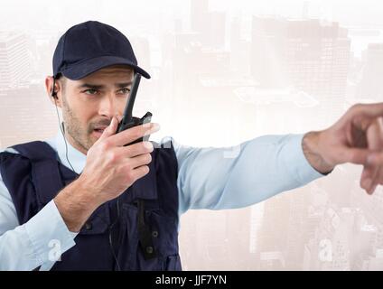 Digital composite of Security guard with walkie talkie pointing against faded skyline Stock Photo