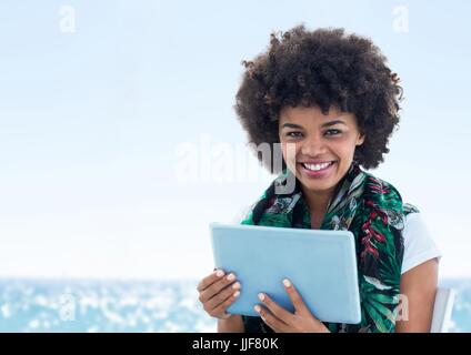 Digital composite of Woman with tablet against blurry water on sunny day Stock Photo