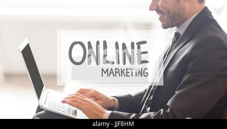 Digital composite of Online marketing text against businessman working on laptop Stock Photo