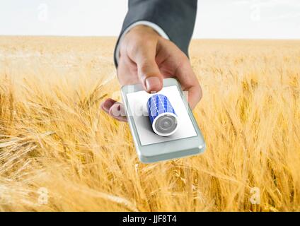 Digital composite of battery solar panel on hand in field Stock Photo