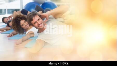 Digital composite of People on yoga matts and yellow bokeh transition Stock Photo