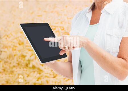 Digital composite of Model in field pointing at tablets screen Stock Photo