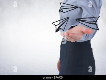 Digital composite of Business woman mid section with white paper airplane doodle in hand against white wall Stock Photo