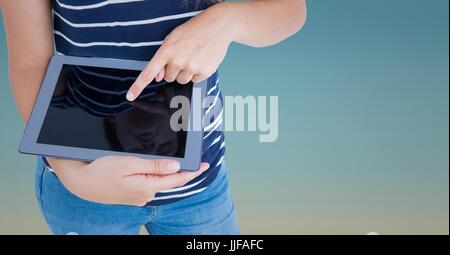 Digital composite of Woman mid section with tablet against blue gradient Stock Photo