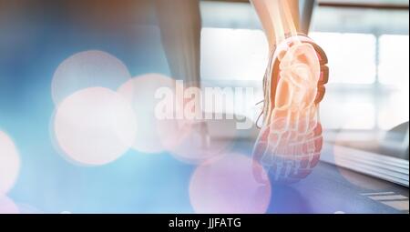 Digital composite of Feet on treadmill and blue bokeh transition Stock Photo