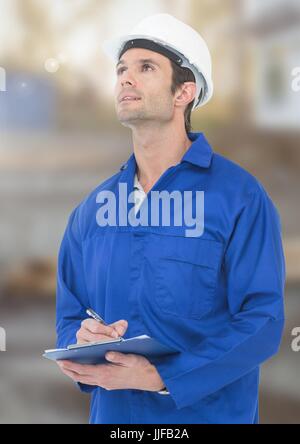 Digital composite of Construction Worker with pen chart in front of construction site Stock Photo