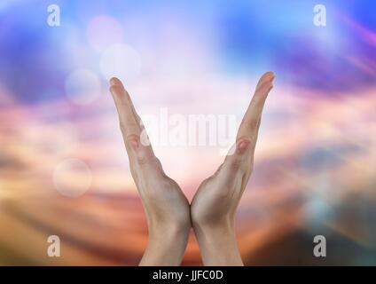 Digital composite of Hands in V shape with abstract light background Stock Photo