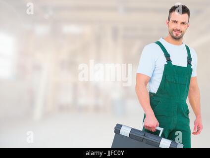 Digital composite of Construction Worker with tool box in front of construction site Stock Photo