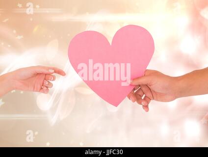 Digital composite of Hands with heart and sparkling light bokeh background Stock Photo