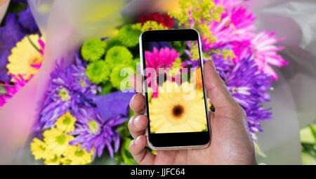 Digital composite of Cropped hand photographing flowers through smart phone Stock Photo