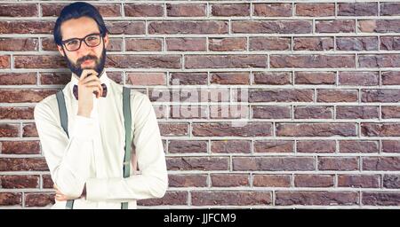 Digital composite of Creative businessman standing against brick wall