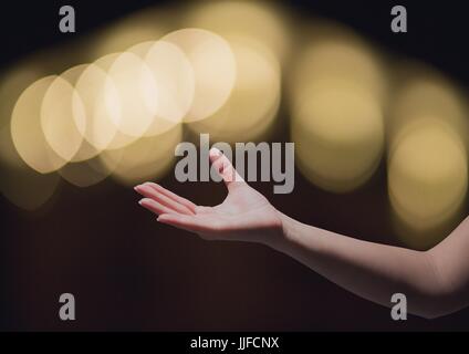 Digital composite of Hand reaching asking in wonder with sparkling light bokeh background Stock Photo