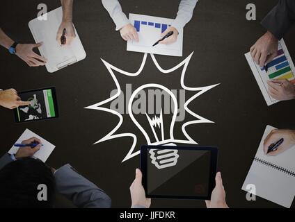 Digital composite of Overhead of business team with blackboard and white lightbulb graphic Stock Photo