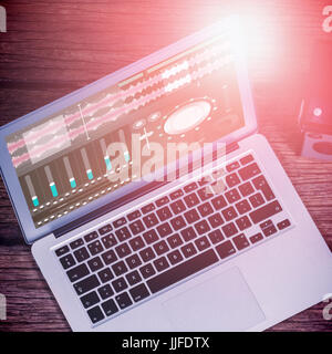 Music app against high angle view of laptop with cameras on table Stock Photo