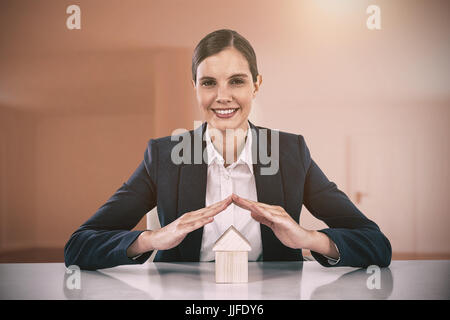 insurer protecting a house by his hands against bright room with two doors Stock Photo