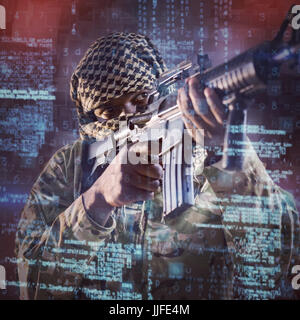 Low angle view of soldier aiming with rifle against overhead view of blocks Stock Photo