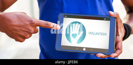 Volunteer text with icons on screen against man pointing at blank screen of digital tablet Stock Photo