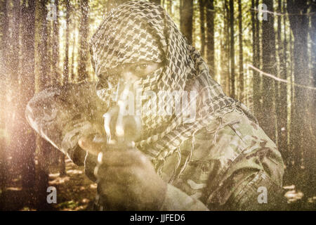 Portrait of face covered soldier aiming with rifle against black Stock ...