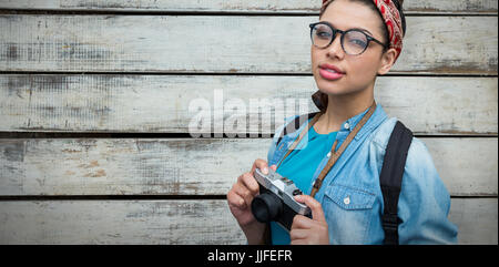 Portrait of young photographer with camera  against wood panels in row Stock Photo