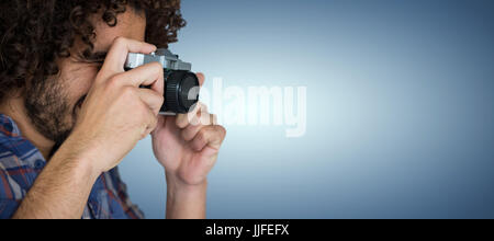 Male photographer taking picture with camera against purple vignette Stock Photo