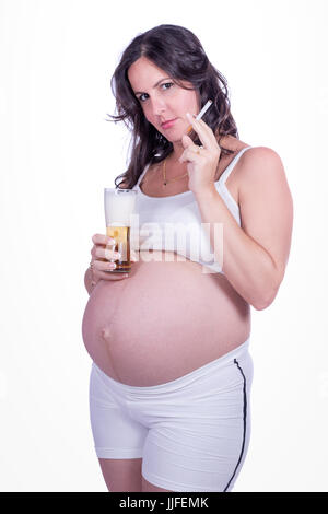 Pregnant woman with a cigarette in one hand and a baso of beer in the other Stock Photo