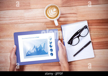 Blue graphics on white background against overhead of feminine hands using tablet Stock Photo