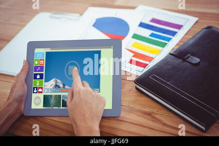 Composite image of various video and computer icons against over shoulder view of hipster woman using tablet Stock Photo