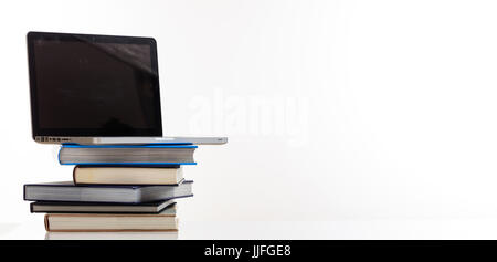 Education concept. Books stack and a laptop isolated on white background - copy space Stock Photo