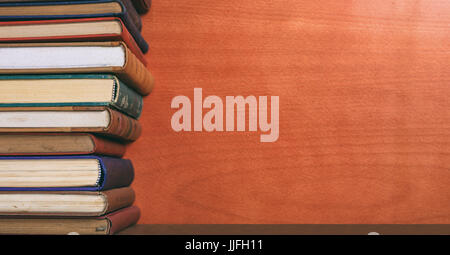 Old books stacked on wooden background - copy space Stock Photo